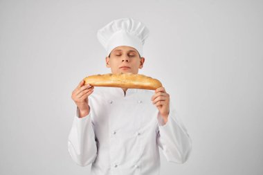 Aşçı kıyafeti giymiş bir adam profesyonel bir fırın endüstrisine bakıyor.