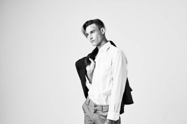 Omzunda ceketi olan beyaz gömlekli bir adam. 