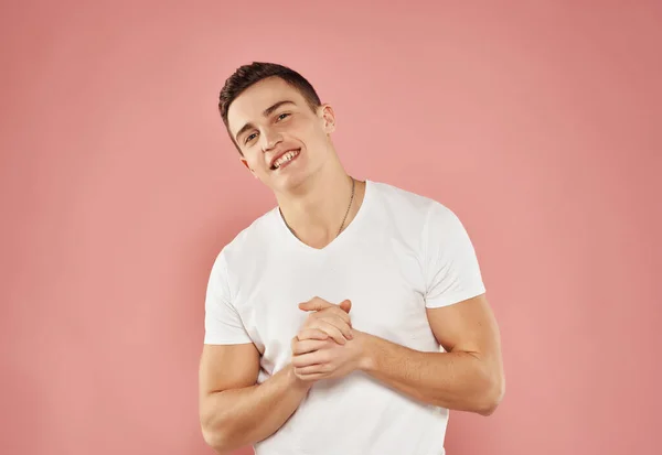 Улыбающийся мужчина в белой футболке обрезанный вид розовый фон — стоковое фото