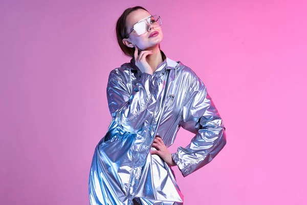 Mooie vrouw zilveren jas mode poseren nachtclub roze achtergrond — Stockfoto