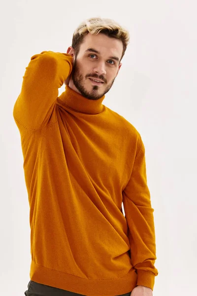 Man in sweater holds his hand behind his head fashion autumn style — Stock Photo, Image