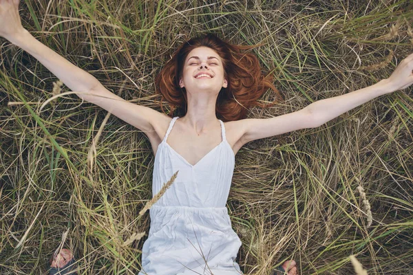 La mujer alegre en el vestido yace sobre la hierba el descanso la naturaleza —  Fotos de Stock