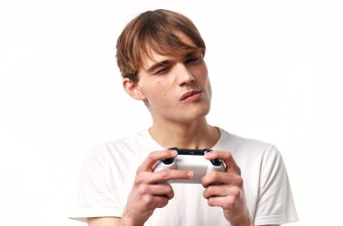 Elinde joystick olan beyaz tişörtlü bir adam eğlence oyunları oynuyor.