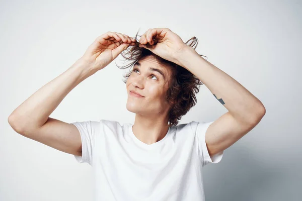 Ragazzo allegro con i capelli arruffati in un bianco T-shirt emozioni primo piano — Foto Stock
