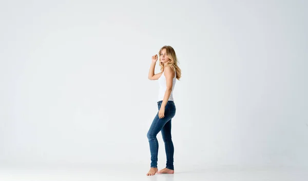 Kvinna i jeans barfota studio positiv energi modell — Stockfoto