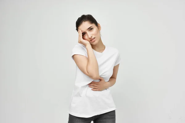 Donna in t-shirt bianca che tiene la pancia problemi di salute dolore addominale — Foto Stock