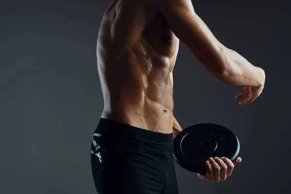Uomo sportivo con un corpo muscoloso pompato in un asciugamano sfondo scuro — Foto Stock