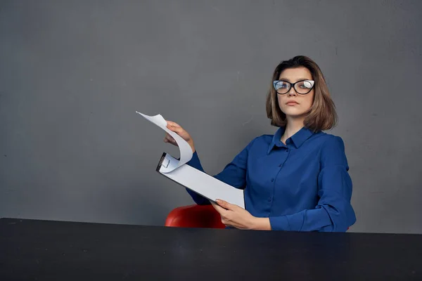 Kobieta w niebieskiej koszuli siedzi przy stole folderu w rękach Kopiuj przestrzeń — Zdjęcie stockowe