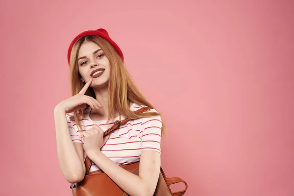 Glimlachende vrouw in rode hoed modieuze kleding emoties roze achtergrond — Stockfoto