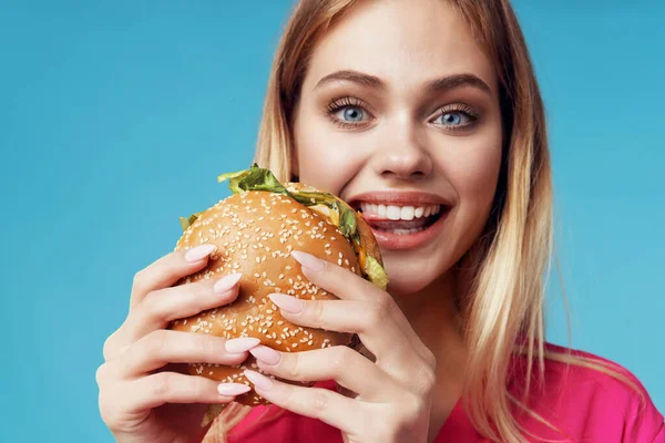 Schattig blond in roze shirt hamburger snack plezier — Stockfoto