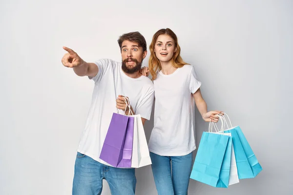 Muž a žena s balíčky v ruce nákupy zábava životní styl sleva — Stock fotografie