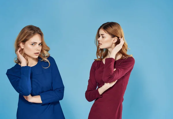 Två kvinnor i klänningar vänskap känslor glamour blå bakgrund — Stockfoto