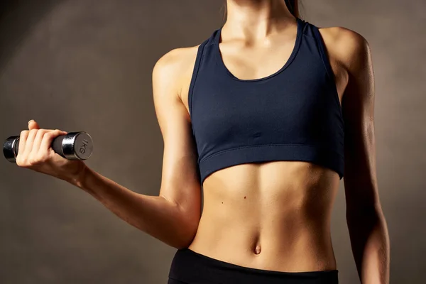 Figura deportiva mujer mancuernas en las manos ejercicios de fuerza bombeado prensa — Foto de Stock