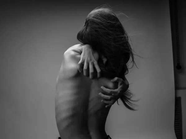 Woman with red hair hands on back back view black and white photo — Stock Photo, Image