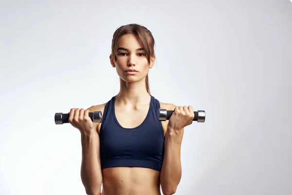 Γυναίκα κρατώντας αλτήρες προπόνηση γυμναστήριο λεπτή σχήμα των μυών — Φωτογραφία Αρχείου