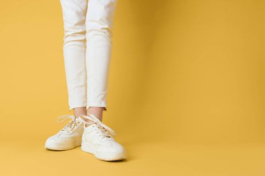 Beyaz kadınların spor ayakkabıları sokak modası pozu veriyordu.