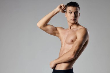 Vücut geliştirici fitness sporcusu gri arka planda kırpılmış görünüm kopyalama alanı