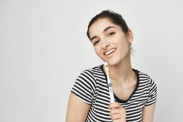 Mulher em listrado t-shirt escova de dentes estilo de vida higiene — Fotografia de Stock
