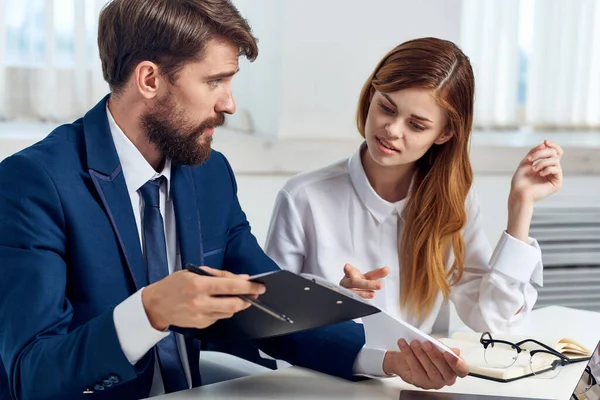 man and woman in business suits looking at the tablet technology office