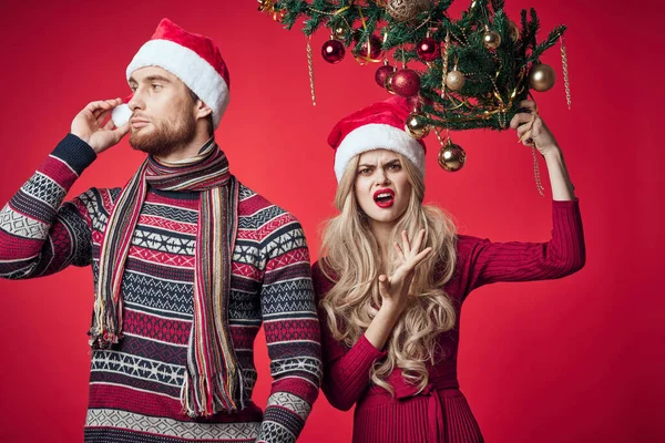 Frau mit einem Weihnachtsbaum in der Hand neben einem Mann — Stockfoto