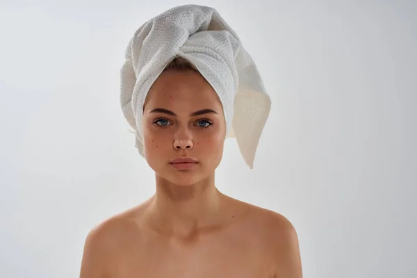 Vrouw met handdoek op hoofd blote schouders heldere huid gezonde lichte achtergrond — Stockfoto