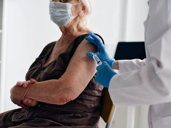 Starší žena pacient nošení lékařské masky pas injekce ochrana imunity — Stock fotografie