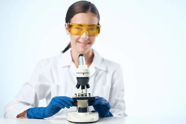 Woman in white coat laboratory microscope research biotechnology