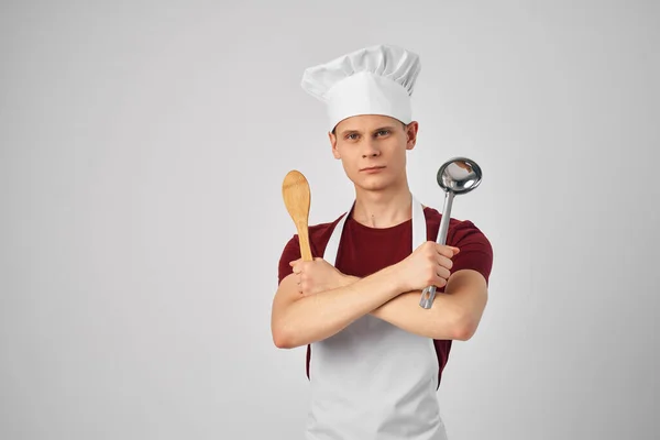 Um homem com uma concha nas mãos cozinhando um trabalho de chefs profissionais — Fotografia de Stock