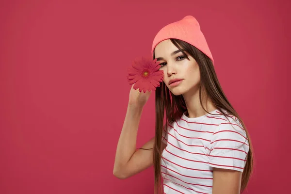 분홍색 모자를 쓰고 빨간 꽃 로맨스 포즈 모델을 하는 여성 — 스톡 사진
