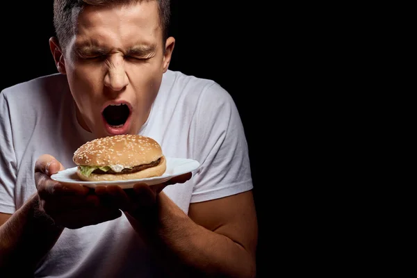 Hombre con hamburguesa comida rápida restaurante comer — Foto de Stock