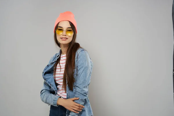 Femme en chapeau rose lunettes jaunes Studio fond gris mode — Photo