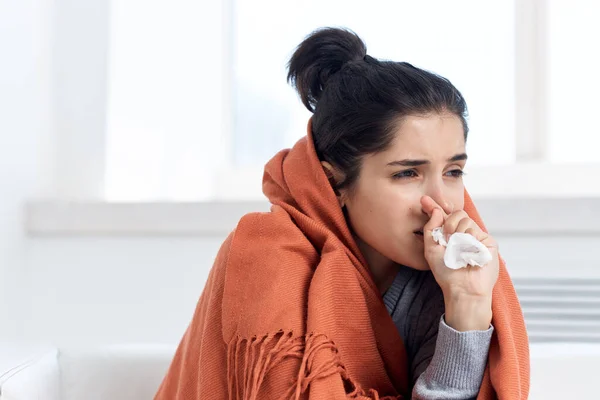 Mujer cubierta con una manta en casa bebiendo medicina — Foto de Stock