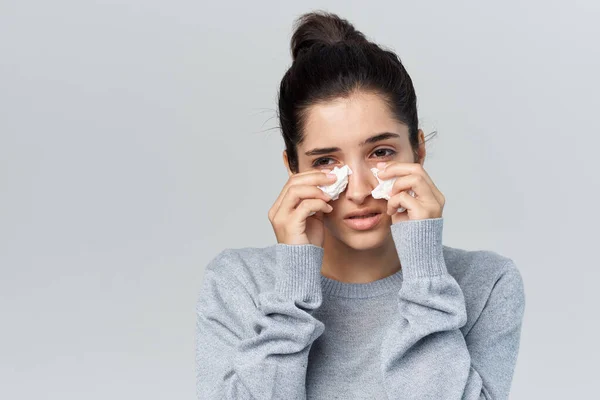 Zieke vrouw op veegt haar neus gezondheidsproblemen licht achtergrond — Stockfoto