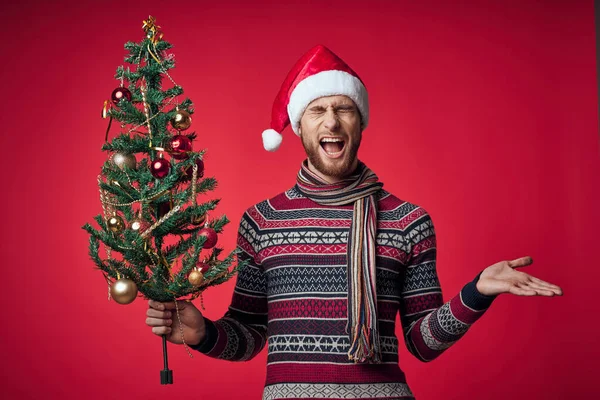 Homme en vêtements de Noël décoration de l'arbre de Noël vacances fond rouge — Photo