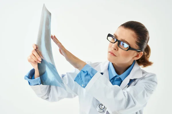 白衣を着た女性医師がX線診断のクローズアップを見て — ストック写真