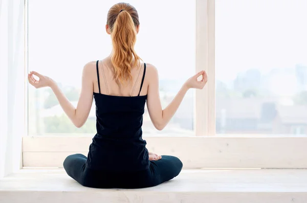 Kadın Pencerenin Yanındaki Meditasyonda Lotus Pozisyonunda Oturuyor Yüksek Kalite Fotoğraf — Stok fotoğraf