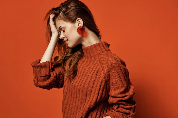 Vrolijke vrouw in rode trui oorbellen charme cosmetica model — Stockfoto