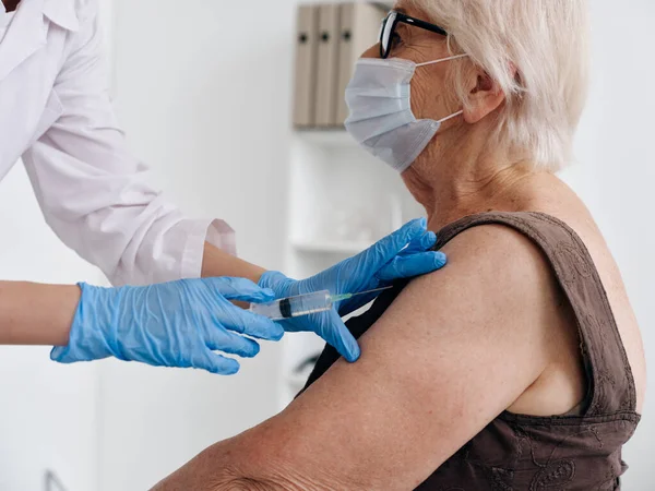 Enfermera administrando una inyección a una mujer anciana paciente vacuna pasaporte — Foto de Stock