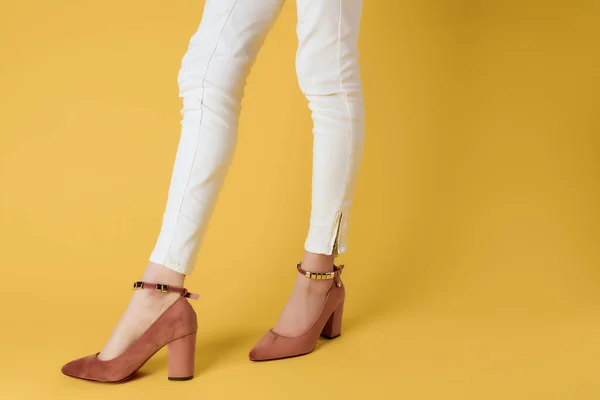 Gambe femminili in pantaloni bianchi scarpe posa primo piano isolato sfondo — Foto Stock