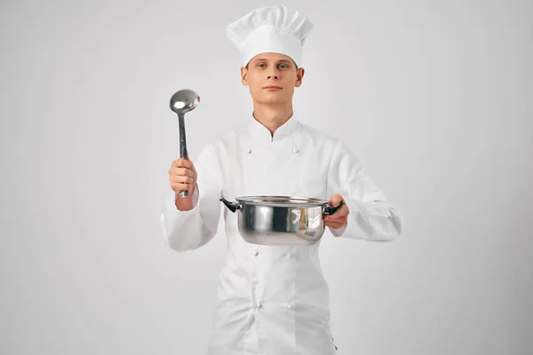 손에 프라이팬을 든 요리사 차림의 남자 가 식당을 준비하고 있다 — 스톡 사진