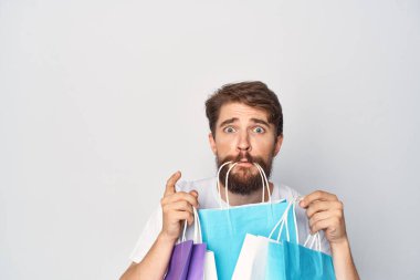 Dişlerinde torba olan bir adam, alışveriş yapıyor. 