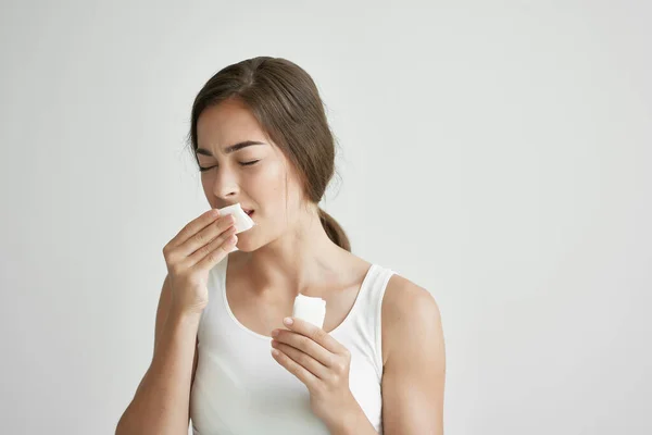 Γυναίκα με λευκό μπλουζάκι φυσάει τη μύτη της σε μια μόλυνση μαντήλι κατάθλιψη — Φωτογραφία Αρχείου