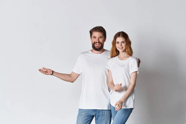 Allegro uomo e donna in bianco t-shirt studio posa design — Foto Stock
