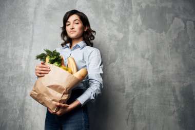 Süpermarketten yemek çantasıyla gülümseyen esmer. 