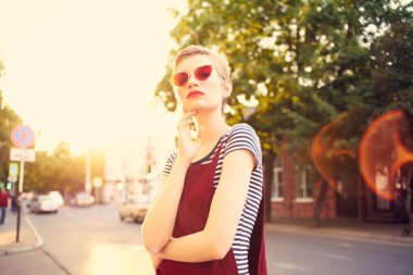 Havalı gözlüklü güzel bir kadın yaz aylarında dışarıda güneş yürüyüşü yapıyor.