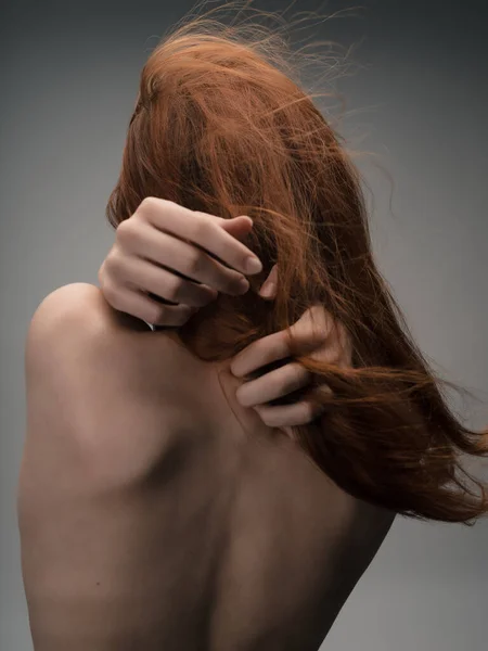 Femme aux épaules nues posant cheveux roux fond isolé — Photo