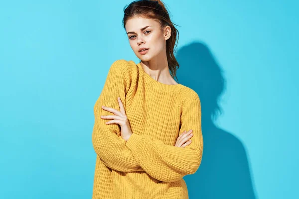 Mujer en suéter amarillo posando Studio moda fondo azul — Foto de Stock