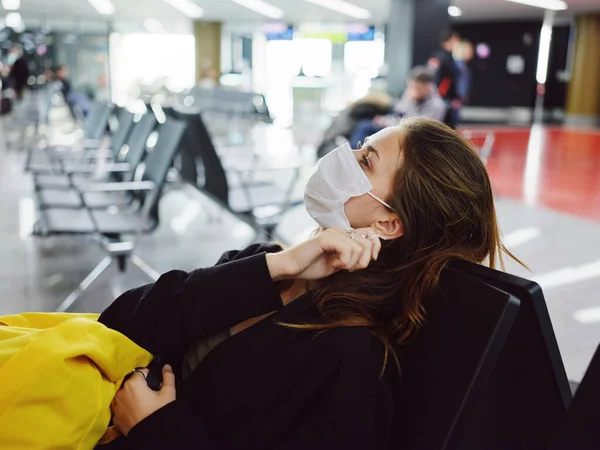 Женщина в медицинской маске отпуск в аэропорту ждет полета — стоковое фото