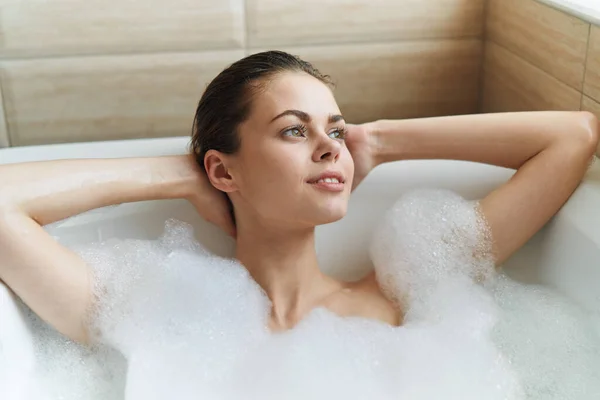 Kvinna ligger i badkaret vitt skum vila ren hud — Stockfoto