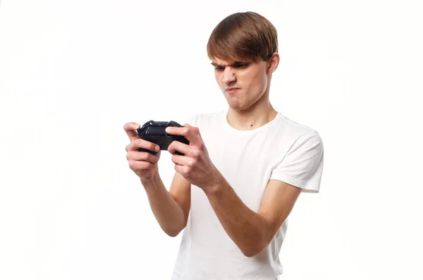 Un hombre con una camiseta blanca con un joystick en las manos jugando hobby estilo de vida —  Fotos de Stock